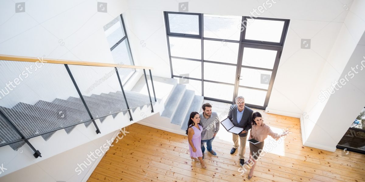 stock-photo-real-estate-agent-showing-new-house-to-couple-with-digital-tablet-400680352